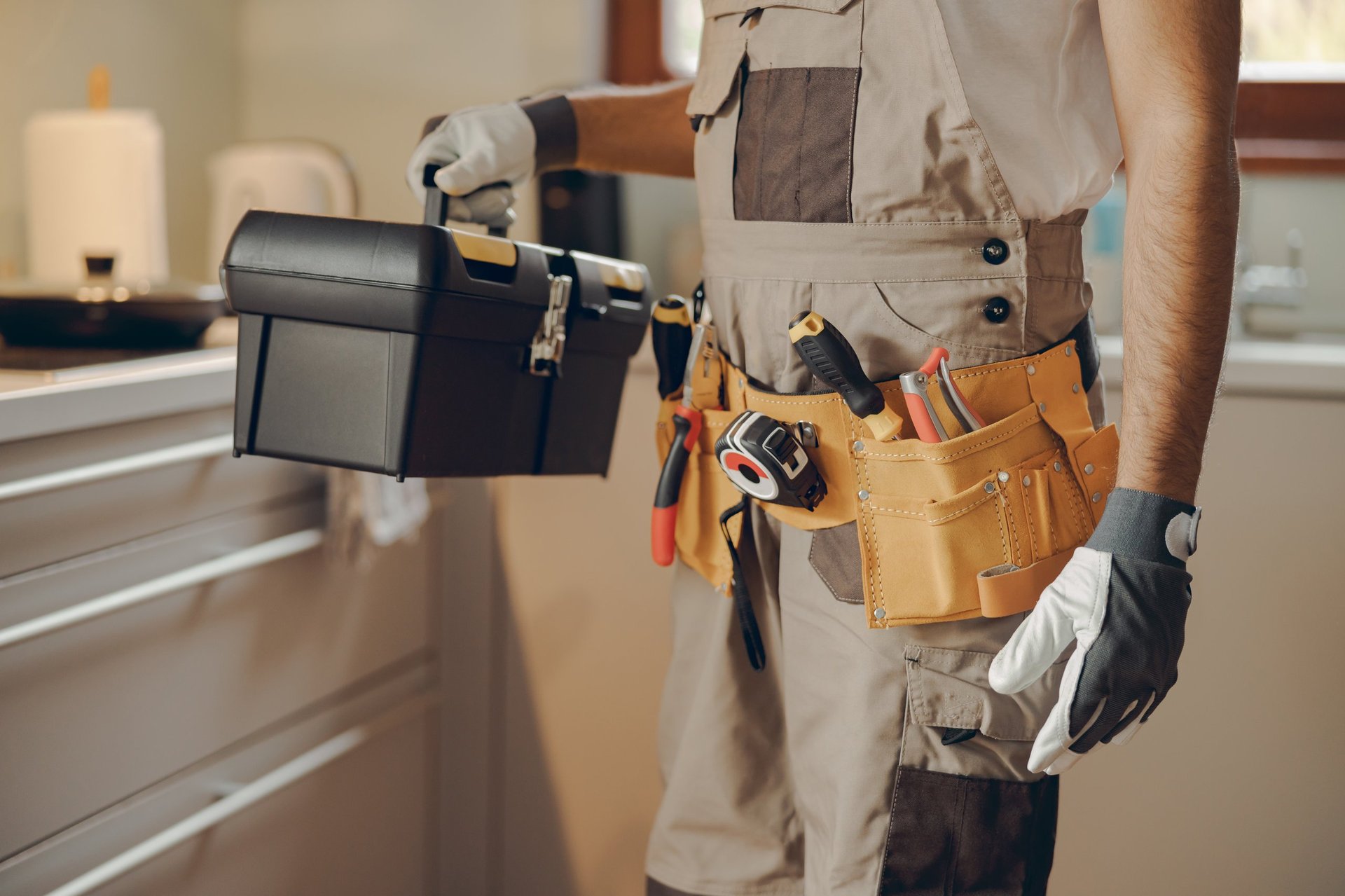 Professional handyman holding his tool bag in a home kitchen