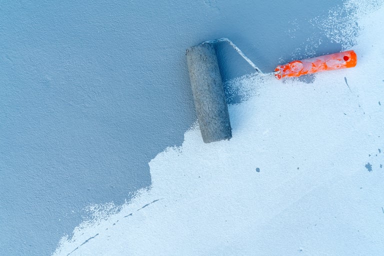 Paint roller applying paint on a textured wall